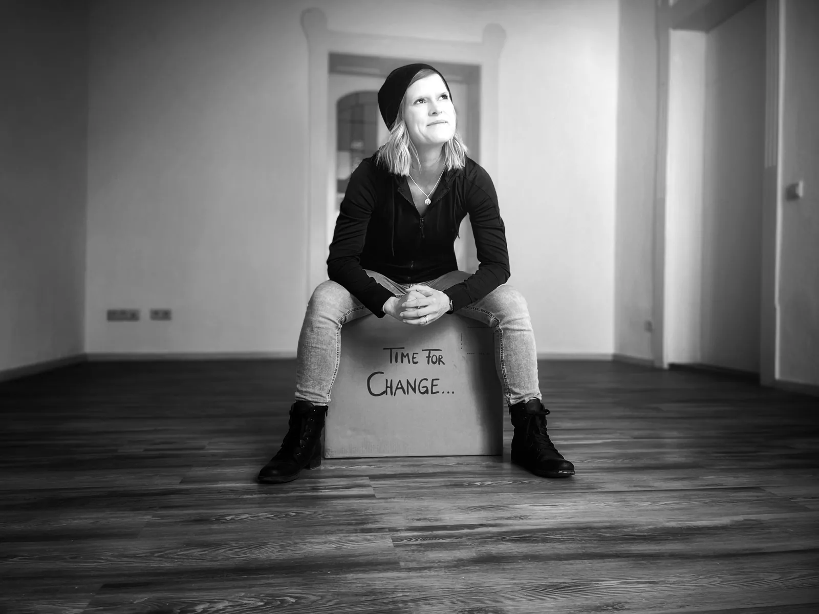 Franziska Kremtz sitzt auf einem Karton mit dem Schriftzug Time for Change